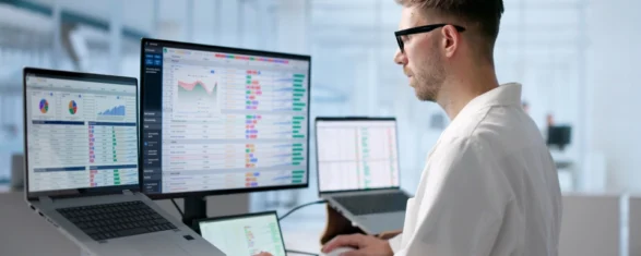 Engineer reviewing software license usage dashboards with charts and reports across multiple monitors