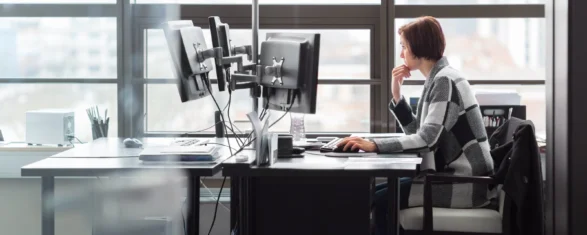 Engineer working at a multi-monitor workstation in an office